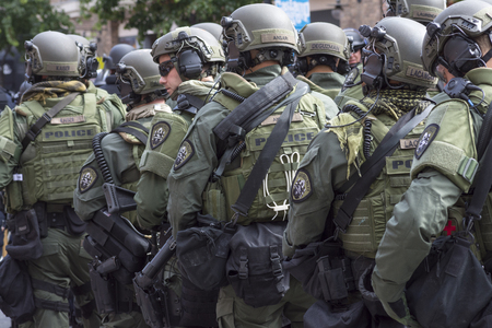 SAN DIEGO, USA - MAY 27, 2016: Riot police stand in formation ready to confront protesters at an anti-Trump rally at the San Diego Convention Centerのeditorial素材