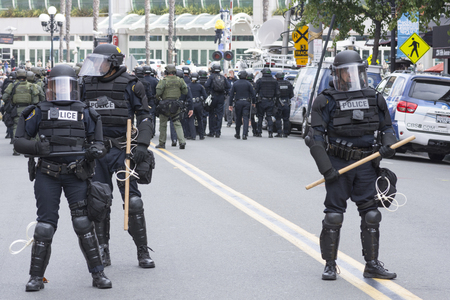 SAN DIEGO, USA - MAY 27, 2016: Riot police in full tactical gear guard the street to the protest area outside a Trump rally in San Diego.のeditorial素材