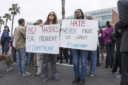 SAN DIEGO, USA - MAY 27, 2016: Two female protesters carry anti-hate signs as they share their thoughts about Donald Trump's presidential campaign outside a rally in San Diego.のeditorial素材