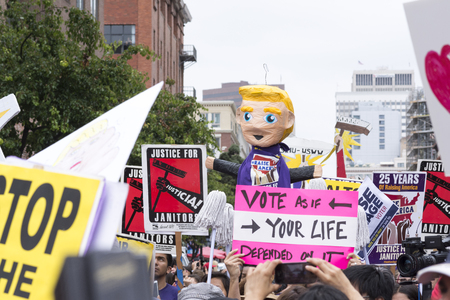 SAN DIEGO, USA - MAY 27, 2016: The anti-Trump crowd marches beneath a huge Donald Trump pinata and justice for unions signs at a protest outside a Trump rally in San Diego.のeditorial素材