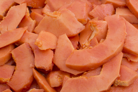 Lot of fresh papaya cut in big pieces in pile for servingの写真素材