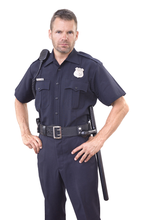 Handsome Caucasian police officer wearing cop uniform stands with authority and bold eyes on white background