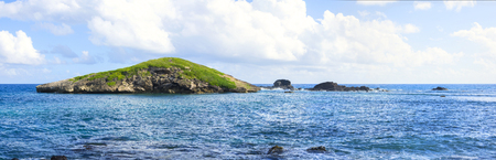 Panoramic of small rocky island of El Ancon at end of Flamenco Peninsula on Caribbean island of Isla Culebra on sunny dayの写真素材