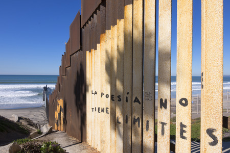 Vertical steel girders create the border wall between Mexico and the United States at the beach in Tijuana, Mexicoの写真素材