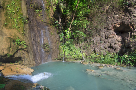 Turquoise blue pool under tranquil waterfalls surrounded by lush green tropical vegetation at La Conchuda waterfall in Rio la Venta Canyon, Chiapas, Mexicoの写真素材