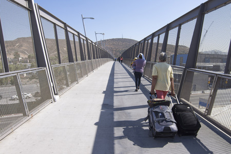 SAN YSIDRO, CALIFORNIA, USA - OCTOBER 5, 2017: Travelers cross the new pedestrian bridge over the interstate 5 freeway to the San Ysidro border crossing into Mexicoのeditorial素材