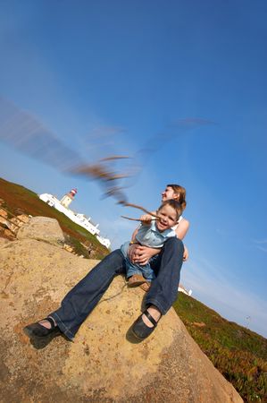 Family fun at Europe?s edge. Mother and son having fun together. Lighthouse of Cabo da Roca ? west most point of Europe ? is on backgroundの写真素材