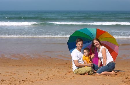 Happy family of three having fun at the beachの写真素材