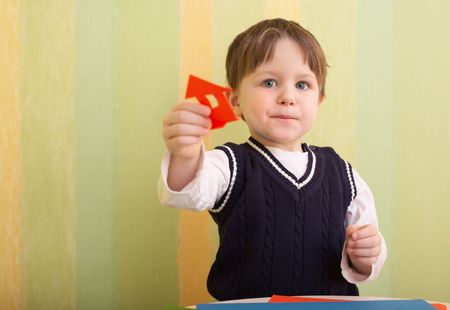 3 years old boy and little house made with color paper and scissorsの写真素材