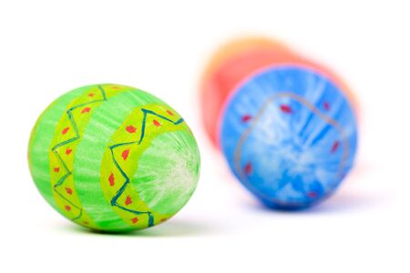 Green hand painted Easter egg and other eggs isolated on white background
