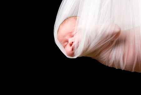 Stork Baby Package. 14 days old newborn baby girl carried in white clothの写真素材