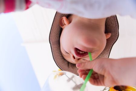 Drinking juice is fun. 4 years old boy drinking juice by strawの写真素材