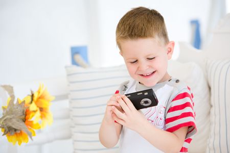 4 years old boy making photo with mobile phoneの写真素材