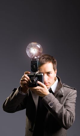 Retro photo journalist holding vintage camera with flash bulbの写真素材