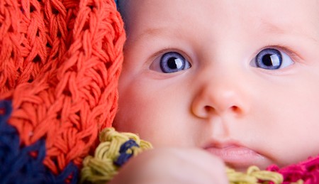 Portrait of three month old baby girl with big blue eyes