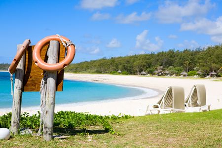 Safe swimming in paradise. Orange life buoys and white sand tropical beach.の写真素材