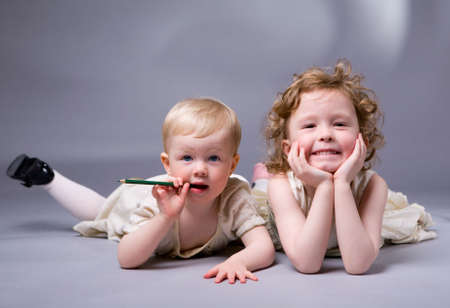 Studio photo of two sisters over gray backgroundの写真素材