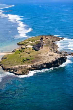 Aerial view of small island with ruins of old lighthouse in turquoise waters of Indian oceanの写真素材