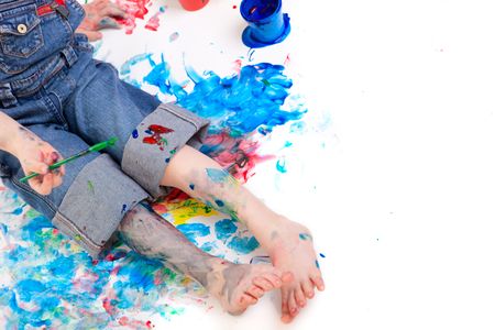 5 years old boy painting with finger paints on white backgroundの写真素材