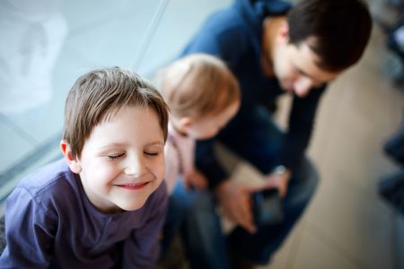Cute boy with his father and baby sister waiting in airportの写真素材