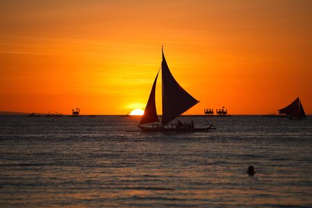 Sailboats against beautiful sunset in Boracay Philippinesの写真素材