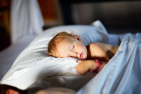 Adorable toddler girl in bedroom at the morningの写真素材