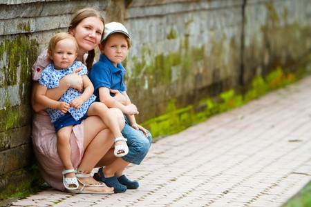 Portrait of young beautiful woman and her two kids outdoorsの写真素材