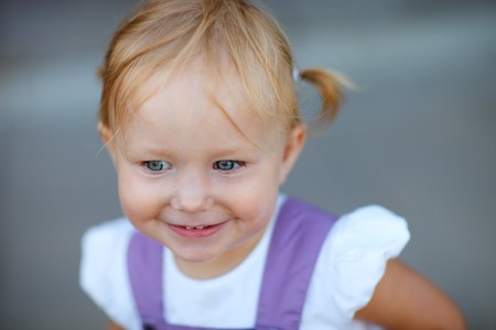 Closeup outdoor portrait of adorable playful 2 years old girlの写真素材