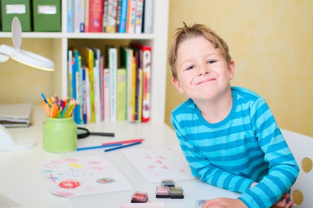 Portrait of cute happy schoolboy at home