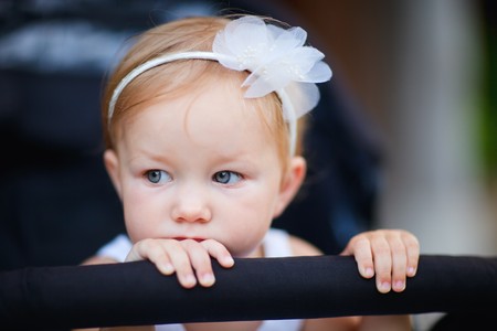 Portrait of adorable toddler girl sitting in strollerの写真素材