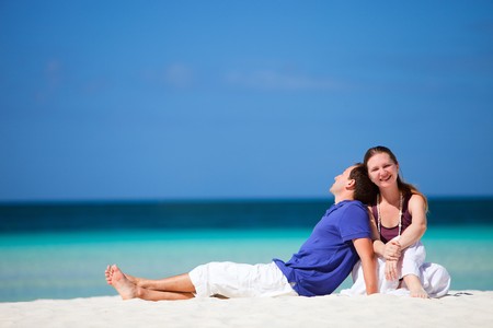 Young happy couple on white sand beachの写真素材