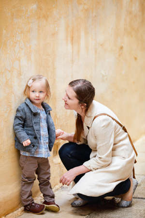 Mother and her little daughter walking in cityの写真素材