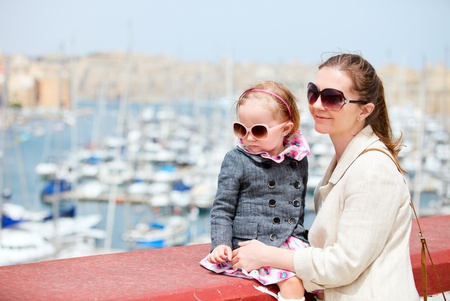 Mother and her little daughter outdoors in city near harborの写真素材