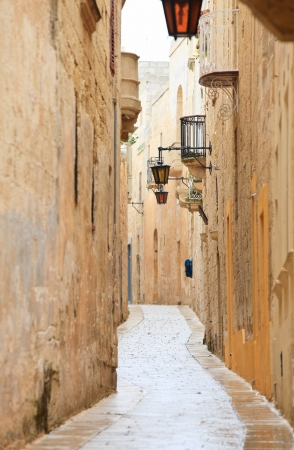 Narrow medieval stone paved street in Mdina the former capital of Malta Narrow medieval stone paved street in Mdina the former capital of Malta