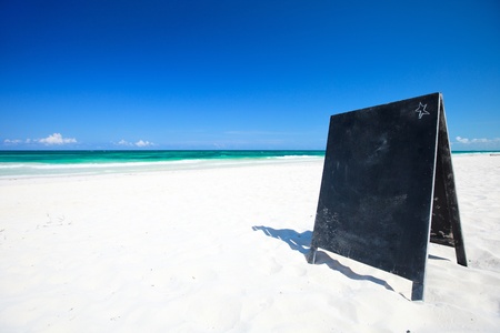 Blank blackboard on beautiful Caribbean beach. Perfect for your addの写真素材