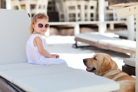 Little girl and golden retriever dog outdoors at beachの写真素材