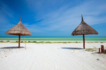 Two umbrellas on stunning tropical beach at Holbox Mexico