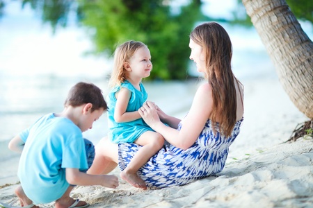 Young mother her two kids enjoying time at beachの写真素材