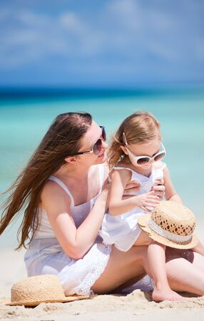Happy mother and daughter at tropical beachの写真素材