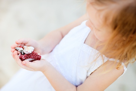 Close up of little girl holding seashells and coralsの写真素材