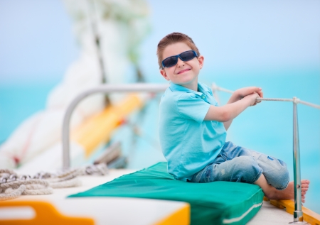 Portrait of cute little boy sailing on luxury yachtの写真素材