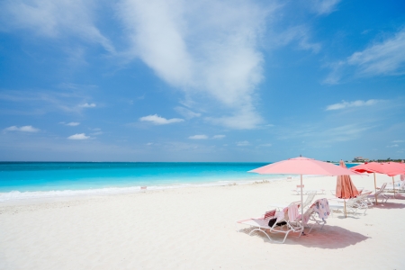 Pink umbrellas on beautiful beach at Providenciales island in Turks and Caicosの写真素材