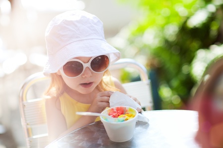 Outdoor portrait of adorable little girl eating ice creamの写真素材