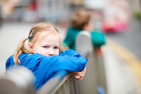Outdoors portrait of cute little girl in a cityの写真素材