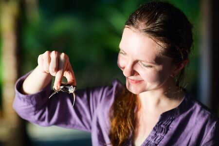Portrait of a beautiful woman holding baby turtleの写真素材