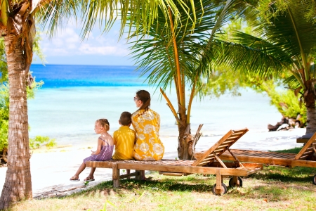 Mother and her two kids on vacation enjoying ocean viewの写真素材