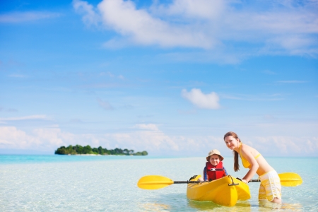 Young beautiful mother and her son preparing for kayakingの写真素材