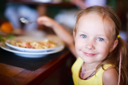 Portrait of adorable little girl having lunchの写真素材