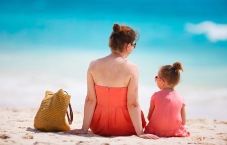 Back view of mother and daughter on a tropical beachの写真素材