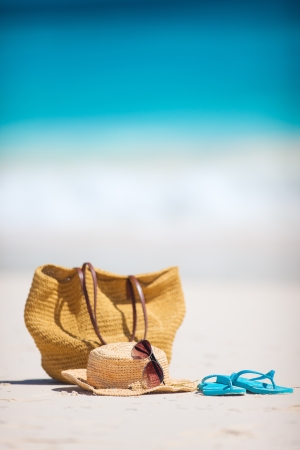 Straw hat, bag, sun glasses and flip flops on a tropical beachの写真素材